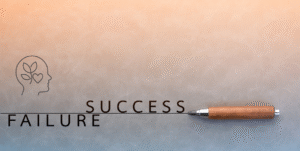 Pen crossing out failure and writing success with a growth mindset icon above