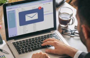 Professional at desk receiving email notification on laptop with red alert badge