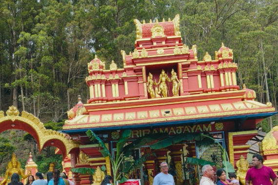 Sita Amman Temple in Nuwara Eliya, Sri Lanka featuring ornate red and gold architecture with multi-tiered roof and golden decorative spires surrounded by forest